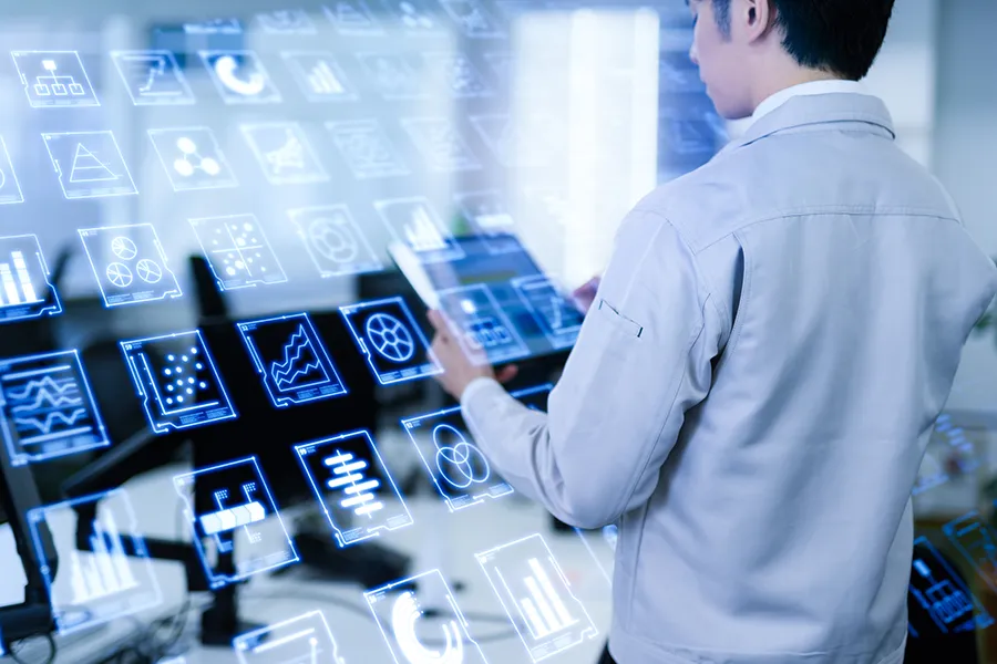 Professional interacting with blue holographic dashboards displaying charts and icons.